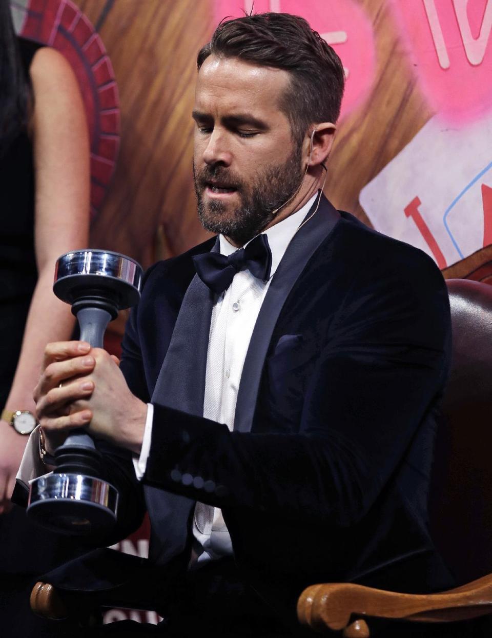 Actor Ryan Reynolds workout with a shake weight during a roast at Harvard University in Cambridge, Mass., Friday, Feb. 3, 2017. Reynolds was honored as "Man of the Year" by the Hasty Pudding Theatricals at Harvard University. (AP Photo/Charles Krupa)