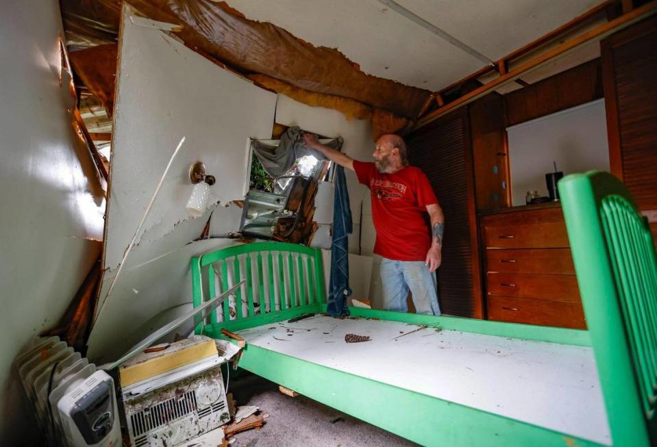 Ron Ganser, 73, looks out a window in his mobile home damaged by a fallen pine tree caused by Hurricane Idalia in Perry Cove Mobile Home and RV Park in Perry, Florida on Wednesday, August 30, 2023. Ganser says he woke up his wife Pat Ganser, 56, to get a cup of coffee and got up has the tree crashed. The wet mattress was removed to dry out since they have nowhere to go for the night.