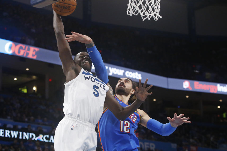 Minnesota Timberwolves center Gorgui Dieng (5) goes to the basket as Oklahoma City Thunder center Steven Adams (12) defends during the first half of an NBA basketball game Friday, Dec. 6, 2019, in Oklahoma City. (AP Photo/Sue Ogrocki)