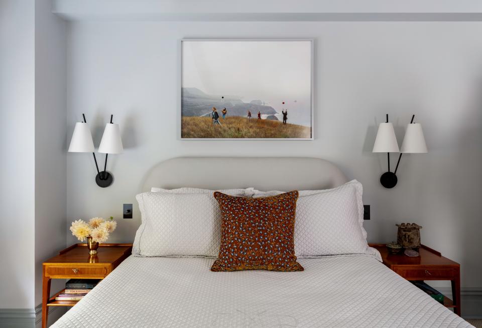 In the bedroom, Rockwell pulled the wall color (Whitestone by Benjamin Moore) from a photograph by Justine Kurland, which he hung above a custom bed flanked with sconces from The Future Perfect and 1930s nightstands from Lawton Mull Art. The Matouk bedding is accented with a pillow from John Derian.