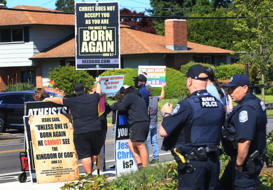 Pride supporters stand in front of protestors outside the 4J Pride Festival at the North Eugene sports field held Friday, June 2, 2023.