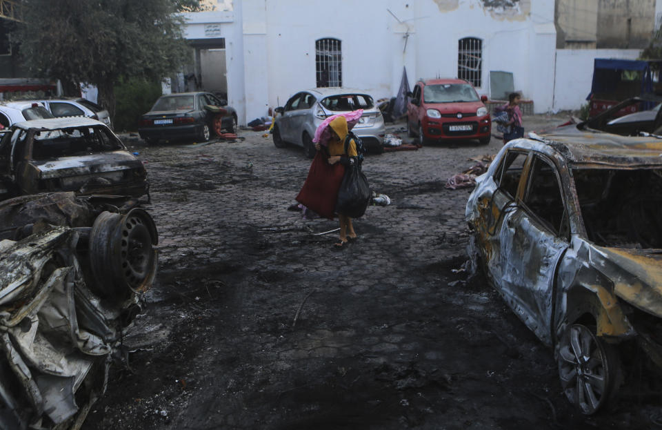 Palestinians carry belongings leave al-Ahli hospital, which they were taking it as a shelter, in Gaza City, Wednesday, Oct. 18, 2023. The Hamas-run Health Ministry says an Israeli airstrike caused the explosion that killed hundreds at al-Ahli hospital, but the Israeli military says it was a misfired Palestinian rocket. (AP Photo/Abed Khaled)