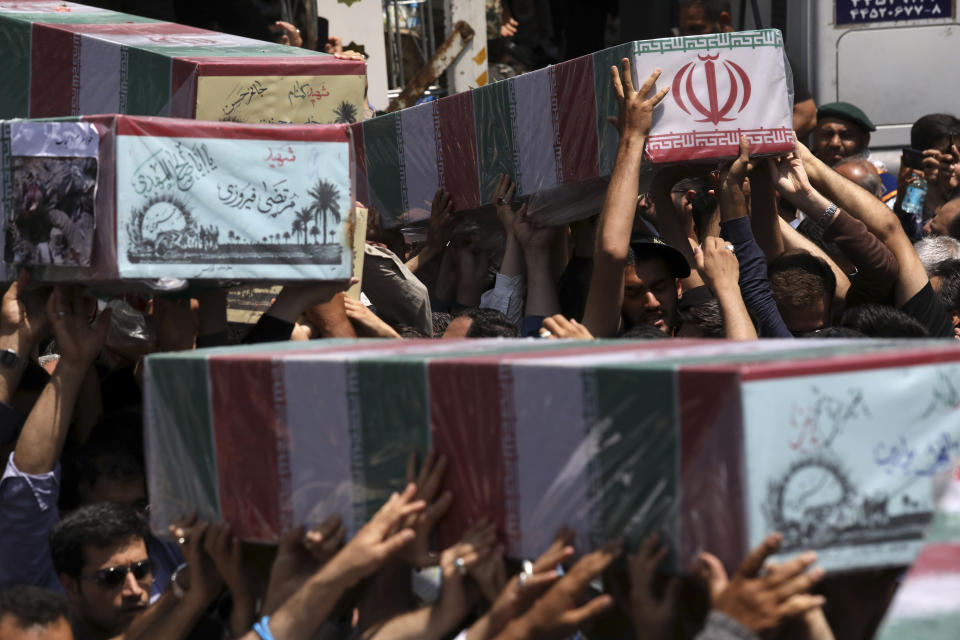 Mourners carry flag-draped caskets in a mass funeral procession for 150 soldiers killed during the war with Iraq in the 1980s, as well as two others killed in Syria in 2016, whose remains were recently recovered in the battlefields, in Tehran, Iran, Thursday, June 27, 2019. (AP Photo/Vahid Salemi)