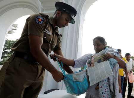 Police officers search the bags of the worshipers at an entrance of the Kelaniya Buddhist temple during Vesak Day, commemorating the birth, enlightenment and death of Buddha, in Colombo, Sri Lanka May 18, 2019. REUTERS/Dinuka Liyanawatte