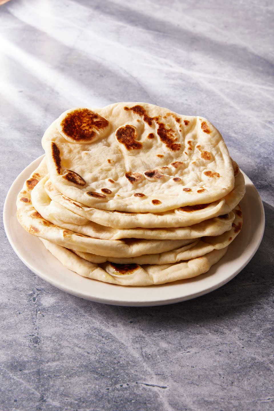 stack of naan bread on a white plate