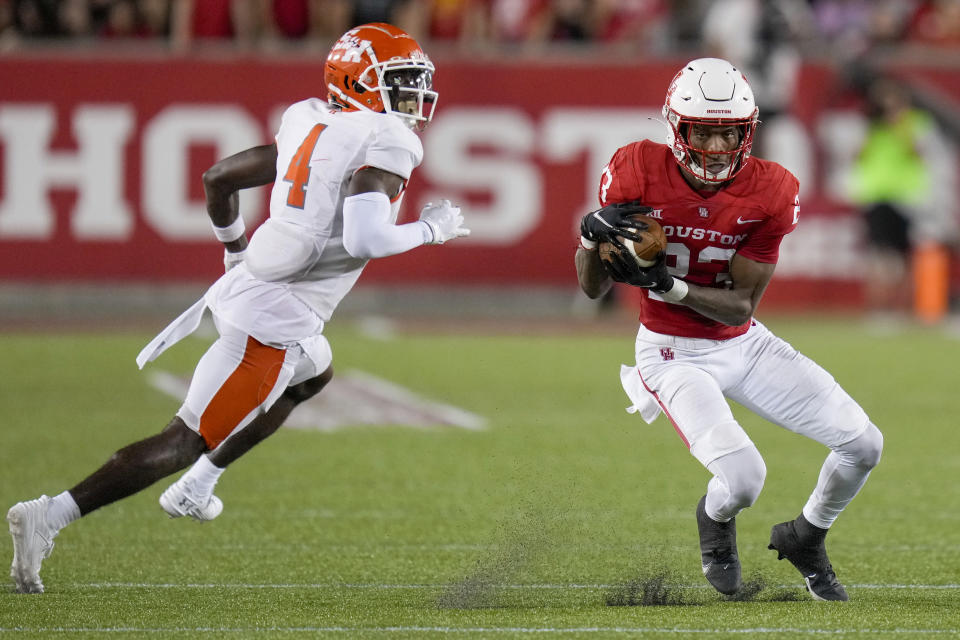 Houston defensive back Johnsley Barbas, right, intercepts a pass intended for Sam Houston State wide receiver Al'vonte Woodard (4) during the second half of an NCAA college football game, Saturday, Sept. 23, 2023, in Houston. (AP Photo/Eric Christian Smith)