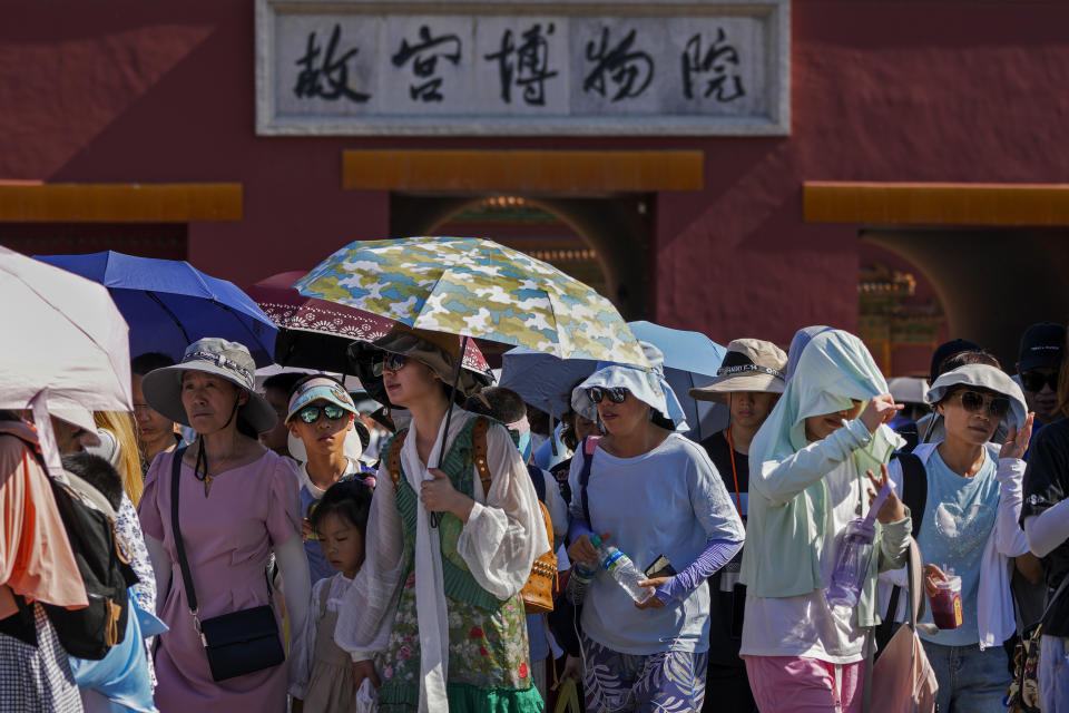 Visitors wear sun hats and carry umbrellas as they leave the Forbidden City on a hot day in Beijing, Thursday, June 29, 2023. The entire planet sweltered for the two unofficial hottest days in human recordkeeping Monday and Tuesday, according to University of Maine scientists at the Climate Reanalyzer project. The unofficial heat records come after months of unusually hot conditions due to climate change and a strong El Nino event. (AP Photo/Andy Wong)