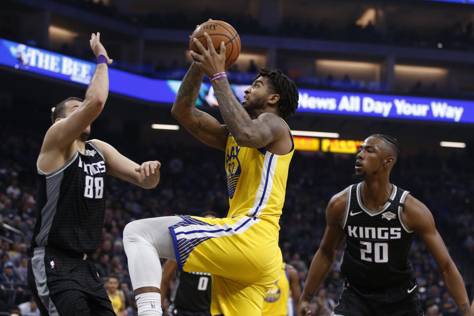 Golden State Warriors forward Marquese Chriss, center, goes to the basket between Sacramento Kings Nemanja Bjelica, left, and Harry Giles III, right, during the first quarter of an NBA basketball game in Sacramento, Calif., Monday, Jan. 6, 2020. (AP Photo/Rich Pedroncelli)