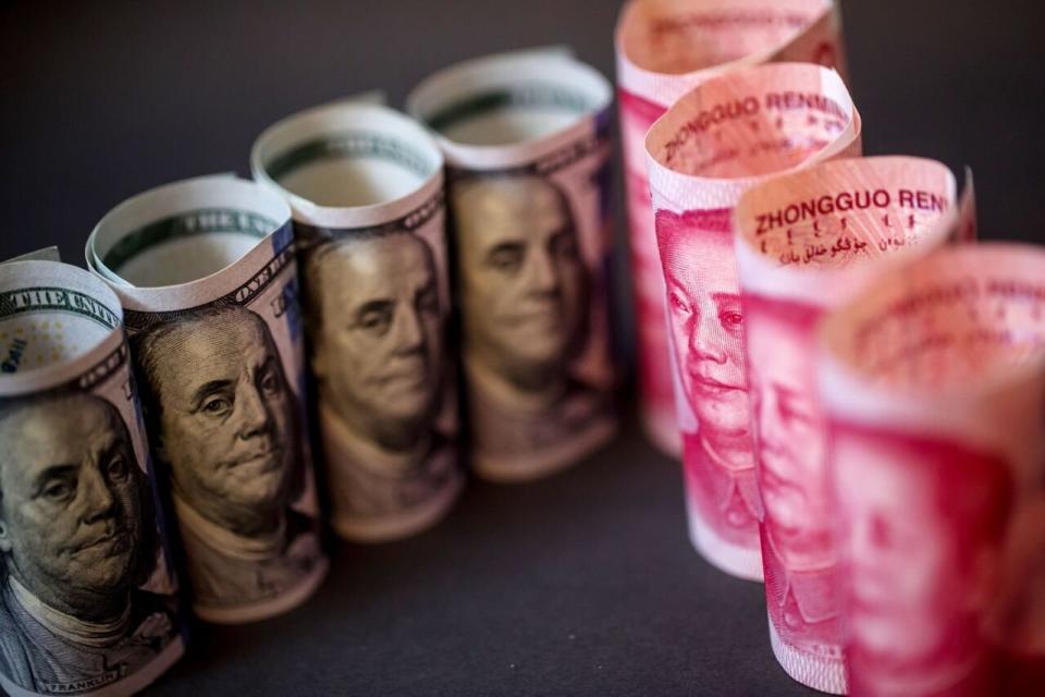 Billetes de cien dólares estadounidenses y billetes de cien yuanes chinos colocados para una fotografía en Hong Kong, China, el lunes 15 de abril de 2019. (Foto: Paul Yeung/Bloomberg vía Getty Images)