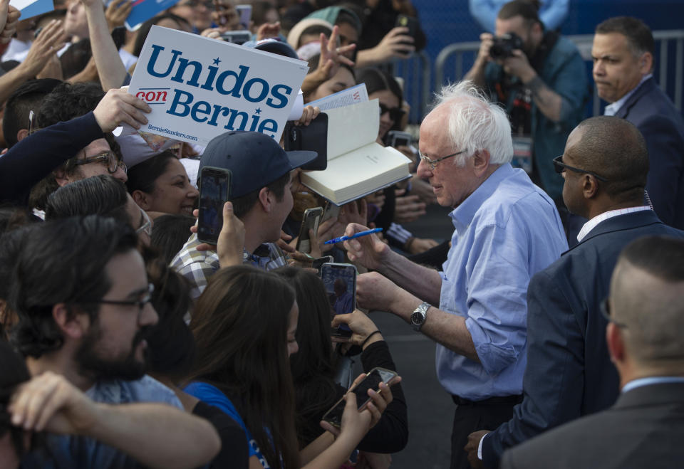 Democratic presidential candidate Sen. Bernie Sanders signs autographs to Latino supporters at a campaign event at Valley High School in Santa Ana, Calif., Friday, Feb. 21, 2020. (Damian Dovarganes/AP)