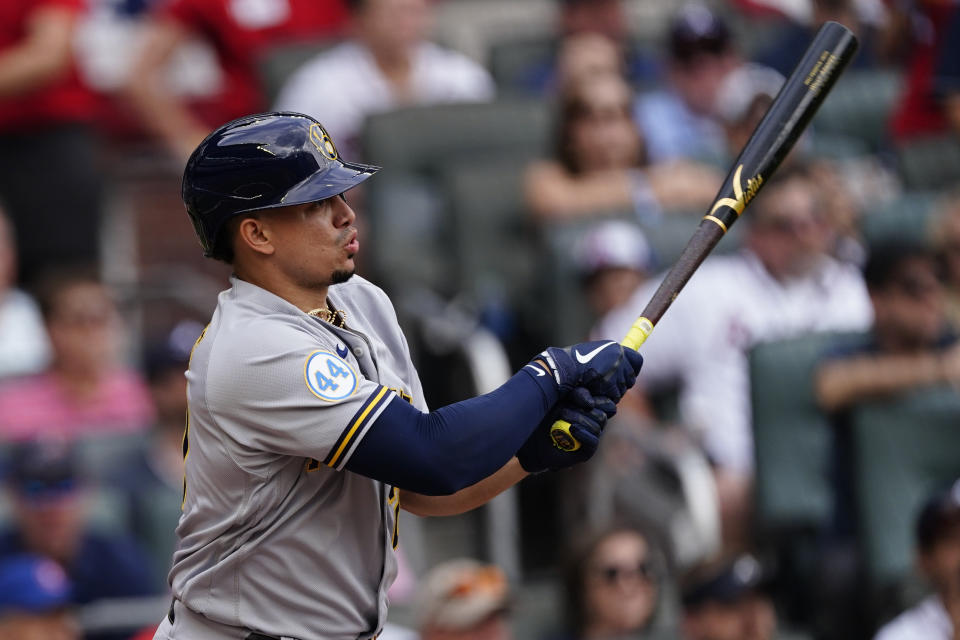 Milwaukee Brewers' Willy Adames (27) gets a base hit during the first inning of Game 3 of a baseball National League Division Series against the Atlanta Braves, Monday, Oct. 11, 2021, in Atlanta. (AP Photo/John Bazemore)