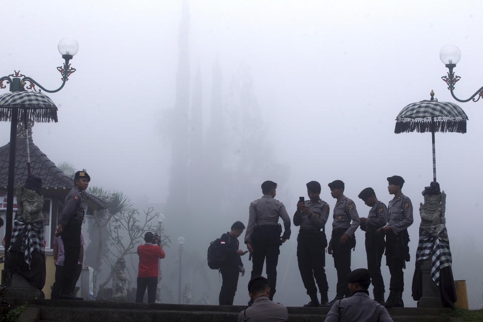 <p>Police officers patrol at Bali’s most prominent temples called Pura Besakih in the fog, a few kilometers away from the mountain’s slopes in Besakih, Bali, Indonesia, Sept. 25, 2017. More than 35,000 people have fled a menacing volcano on the Indonesia tourist island of Bali, fearing will erupt for the first time in more than half a century as increasing tremors rattle the region. (AP Photo/Firdia Lisnawati) </p>