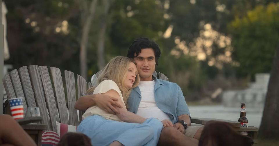 Julianne and Charles cuddling on garden chairs in a scene from from "May December"