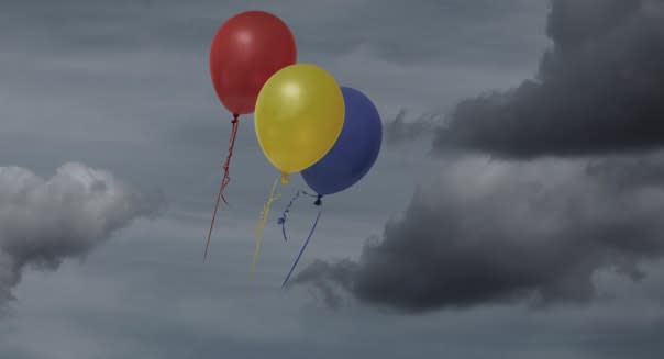 Balloons floating through dark sky