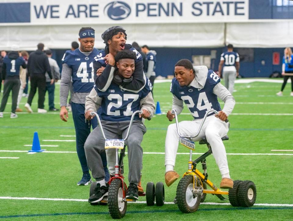 Penn State football players play around on tricycles on Saturday, Feb. 17, 2024 in Holuba Hall.  