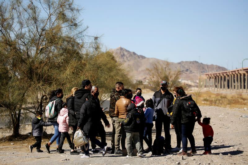 FILE PHOTO: Migrants stand near the Rio Bravo river before crossing it to turn themselves in to request for asylum in El Paso, Texas, U.S., in Ciudad Juarez