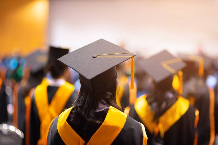 the back view of students wearing graduation hats and gowns