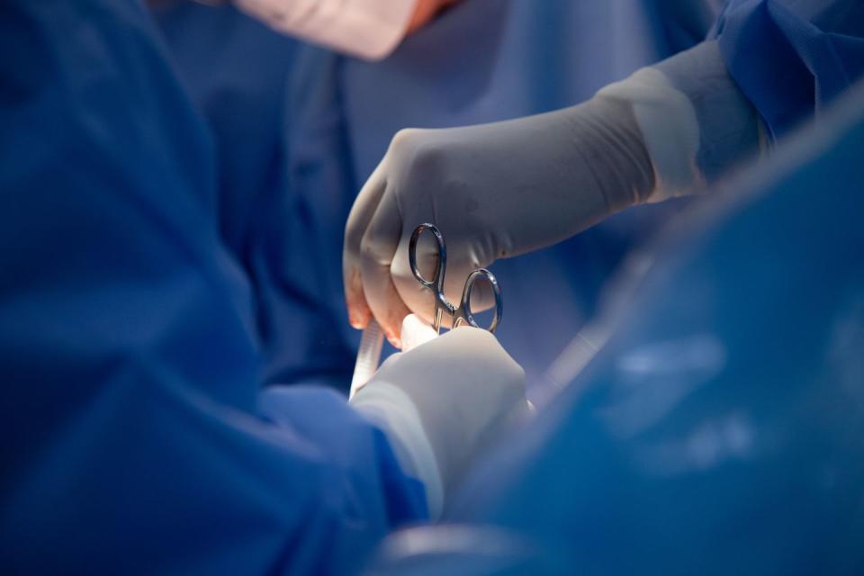 medical team of surgeons in hospital doing caesarean