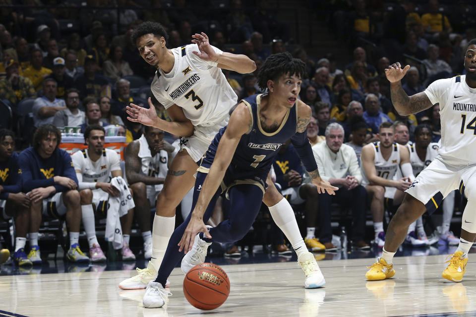 Mount St. Mary's guard Dakota Leffew (1) is defended by West Virginia forward Tre Mitchell (3) during the first half of an NCAA college basketball game in Morgantown, W.Va., Monday, Nov. 7, 2022. (AP Photo/Kathleen Batten)