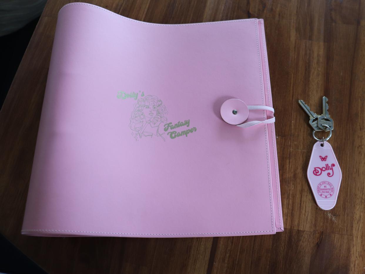 A pink guestbook and key for a Dolly Parton-themed RV