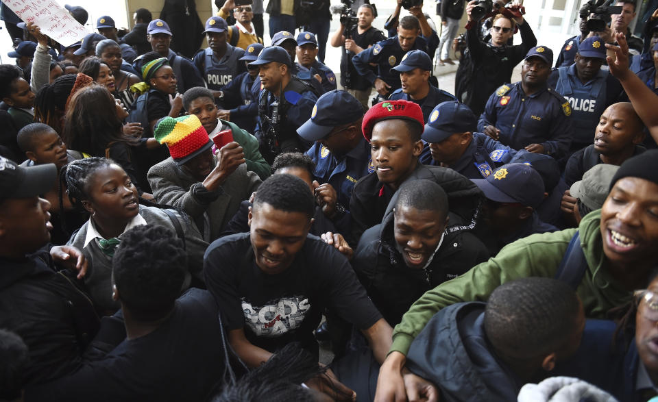 Protesters break through a police cordon to gain entry where the World Economic Forum on Africa is being held in Cape Town, South Africa, Wednesday, Sept. 4, 2019. The women are demanding that the government crack down on gender-based violence, following a week of brutal murders of young South African women that has shaken the nation. (AP Photo)