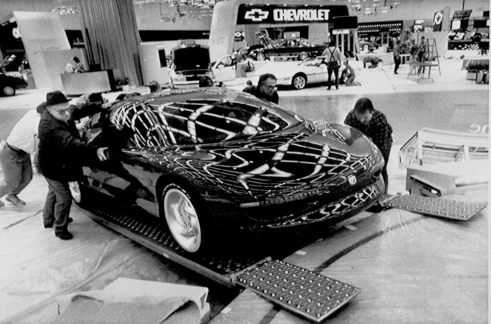 FILE -In this Jan. 2, 1990, file photo, workers roll a Mercury Cyclone concept car up a ramp into its display area as work continues at Cobo Center in Detroit for the North American International Auto Show. The annual event has since grown to be one of most important shows on the auto industry’s calendar. (AP Photo/Richard Sheinwald, File)