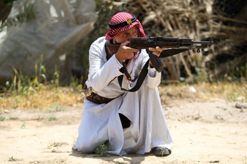 Palestinian refugee Mahmoud Abu Deeb, a former fighter from the village of Beersheba, aims a Kalashnikov AK-47 assault rifle outside his home in Khan Younis in the southern Gaza Strip, on May 15, 2020. On November 13, 1947, the Soviet Union completed development on the AK-47. File Photo by Ismael Mohamad/UPI