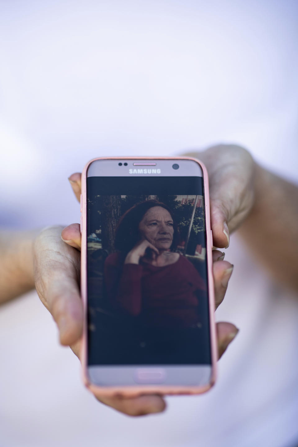 En esta imagen, tomada el 20 de mayo de 2020, Ana Belén muestra una fotografía de su madre, María Pérez López, de 75 años, en Madrid, España. Pérez López es una de las residentes en el Centro de Mayores de Usera que murió por el brote de coronavirus en España. Más de 19,000 muertes de ancianos con coronavirus o sus síntomas en España han propiciado el examen de un sistema en el que residencias públicas acaban en manos de firmas de capital riesgo. (AP Foto/Bernat Armangué)