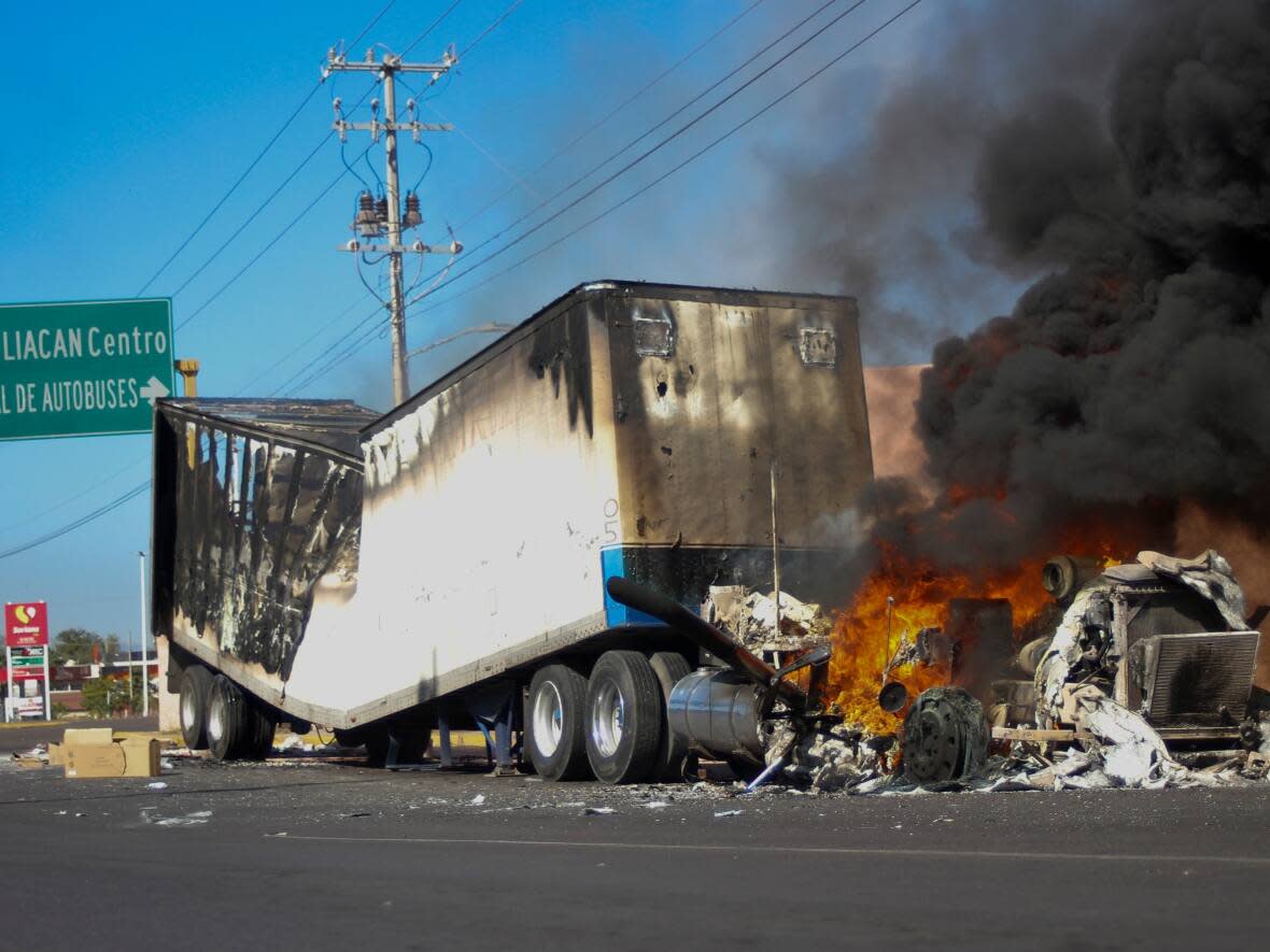 A truck burns on a street in Culiacan, Sinaloa state, on Thursday. Mexican security forces captured Ovidio Guzmán, an alleged drug trafficker in a pre-dawn operation Thursday that set off gunfights and roadblocks across the western state’s capital. (Martin Urista/The Associated Press - image credit)