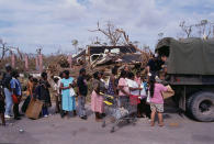 <p>Army personnel pass out supplies from the back of a truck to victims of Hurricane Andrew. (Steve Starr/CORBIS/Corbis via Getty Images) </p>