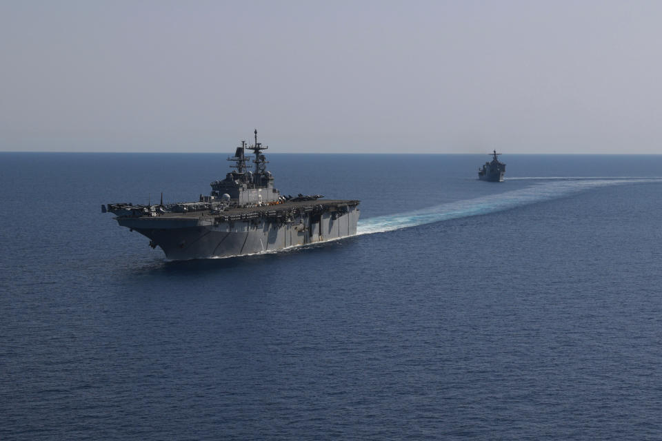 In this photo released by the U.S. Navy, the amphibious assault ship USS Bataan, front, and the landing ship USS Carter Hall, back travel through the Red Sea, Tuesday, Aug. 8, 2023. Western-backed maritime forces in the Middle East on Saturday, Aug. 12, warned shippers traveling through the strategic Strait of Hormuz to stay as far away from Iranian territorial waters as possible to avoid being seized, a stark advisory amid heightened tensions between Iran and the U.S. (Mass Communication Specialist 3rd Class Riley Gasdia/U.S. Navy, via AP)