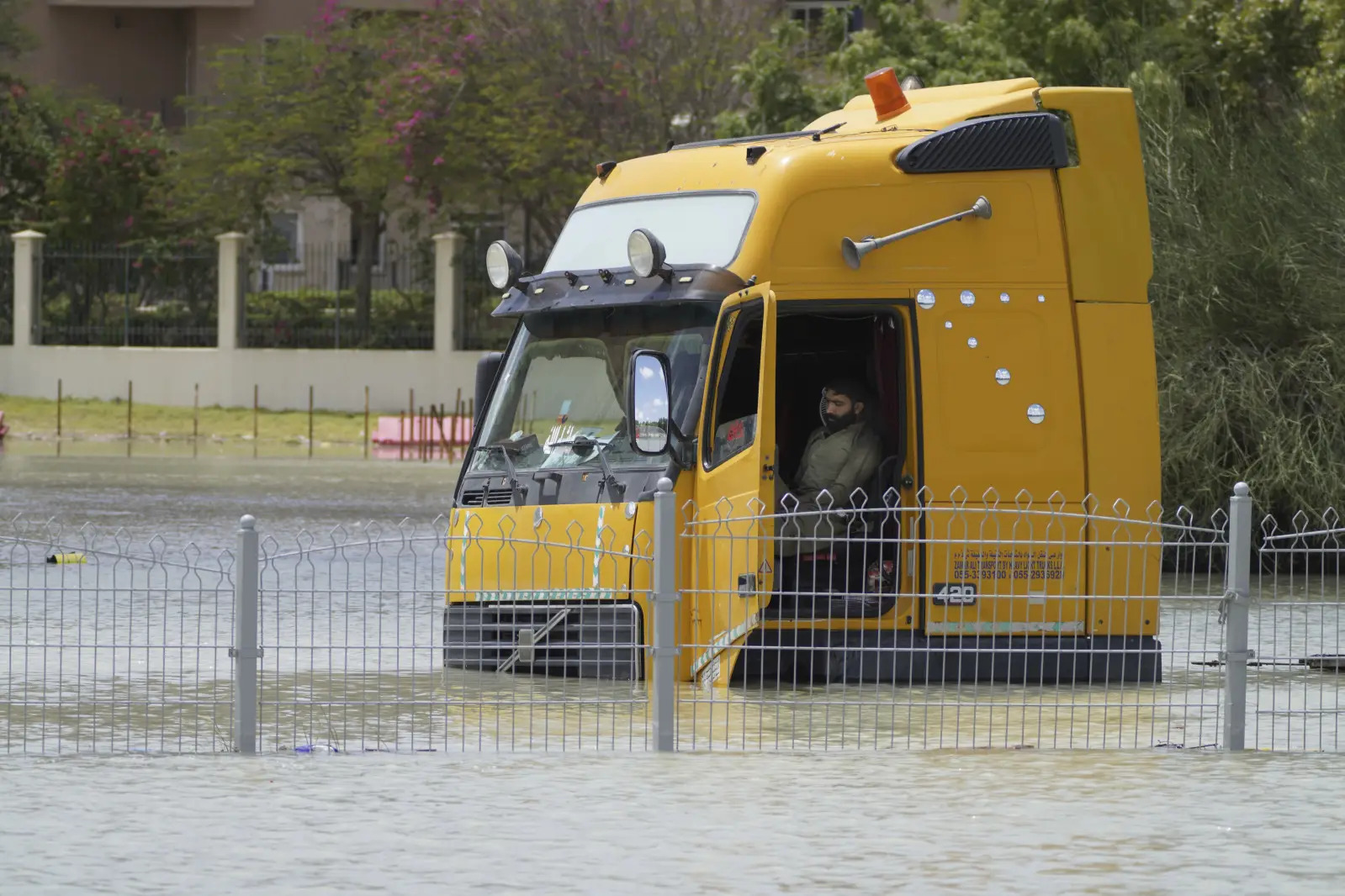 A man sits in a semitruck stuck in floodwater in Dubai.