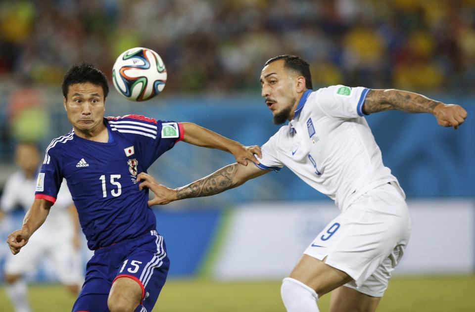 Japan's Yasuyuki Konno (L) and Greece's Konstantinos Mitroglou fight for the ball during their 2014 World Cup Group C soccer match at the Dunas arena in Natal June 19, 2014. REUTERS/Toru Hanai