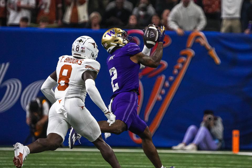 Washington wide receiver Ja’Lynn Polk (2) makes a catch over Texas Longhorns defensive back Terrance Brooks (8) during the Sugar Bowl College Football Playoff semifinals game at the Caesars Superdome on Monday, Jan. 1, 2024 in New Orleans, Louisiana.