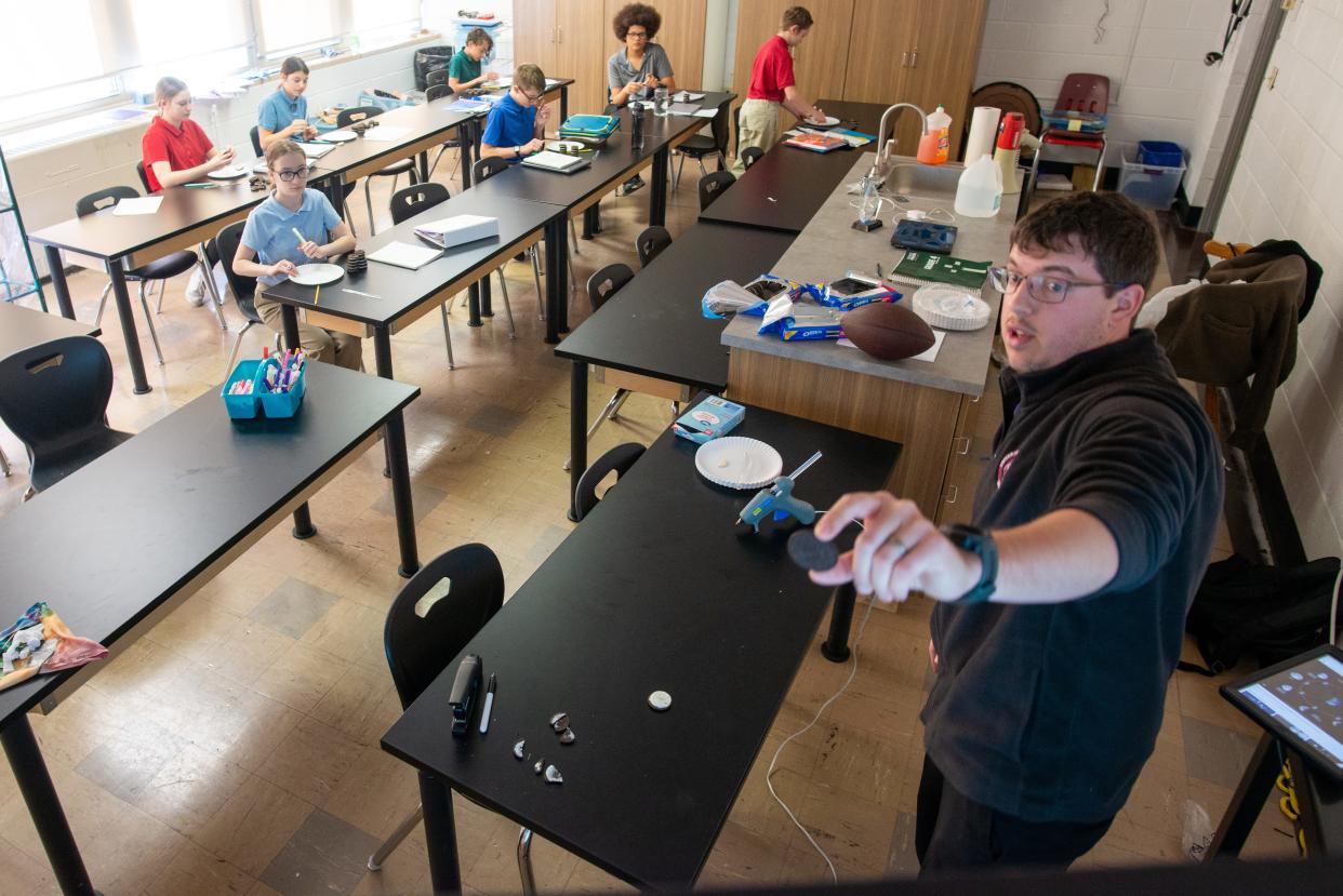 Topeka Lutheran School teacher Joshua Grass on Thursday compares a piece of an Oreo cookie to the moon phases as he teaches seventh- and eighth-grade students.