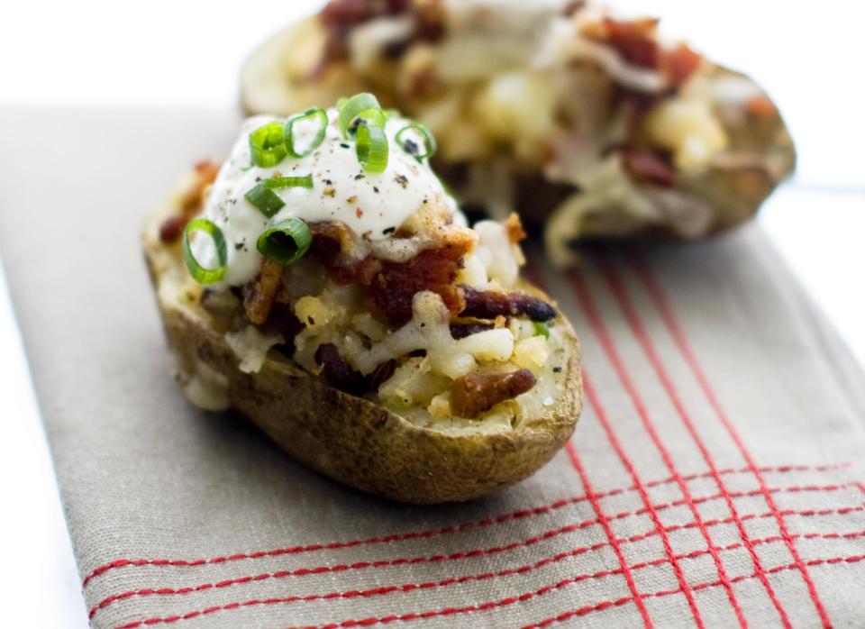 This Jan. 6, 2014 photo shows seven layer potato skins in Concord, N.H. Everybody seems enraptured by seven-layer dip. So for this year’s Super Bowl party, why not freshen it up a bit? Take the same concept of shoveling piles of delicious toppings into your mouth, but instead of chips use a slab of roasted potato. (AP Photo/Matthew Mead)