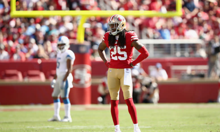 Richard Sherman standing on the field with his arms on his hips during a 49ers game.