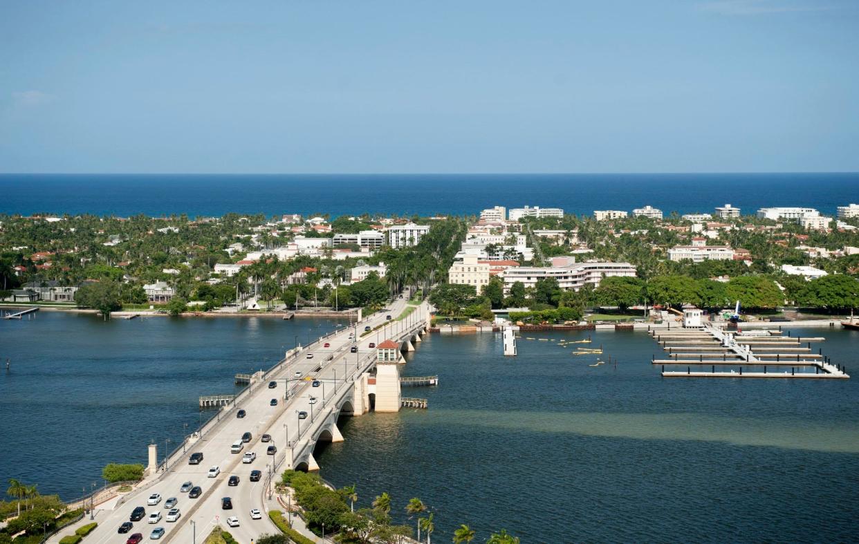 Traffic flows in and out of wealthy Palm Beach on the Royal Park Bridge, which connects the barrier-island town to the mainland in the foreground. Palm Beach property owners will soon be mailed estimates of their 2023 tax bills by the Palm Beach County Property Appraiser's office.
