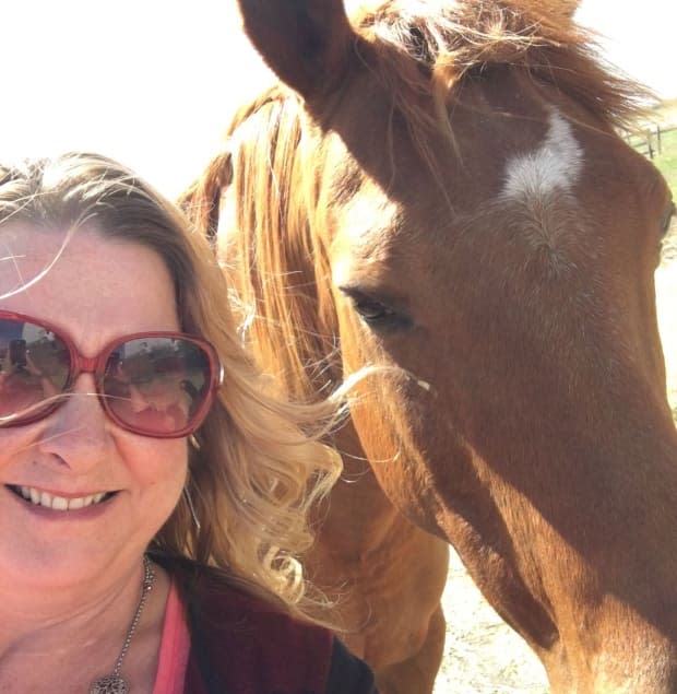 Michelle McKeaveney poses with one of the horses currently being used in equine-assisted therapy, which will be a part of the retreat. 