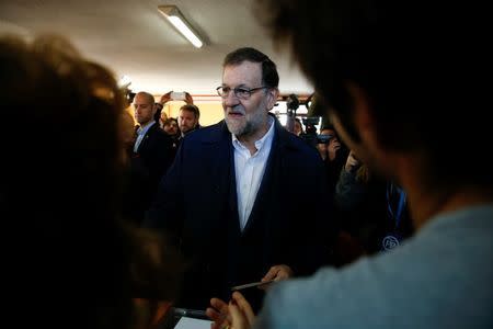 Spain's Prime Minister and Popular Party (PP) candidate Mariano Rajoy holds his ballot before casting his vote in Spain's general election in Madrid, Spain, December 20, 2015. REUTERS/Sergio Perez -