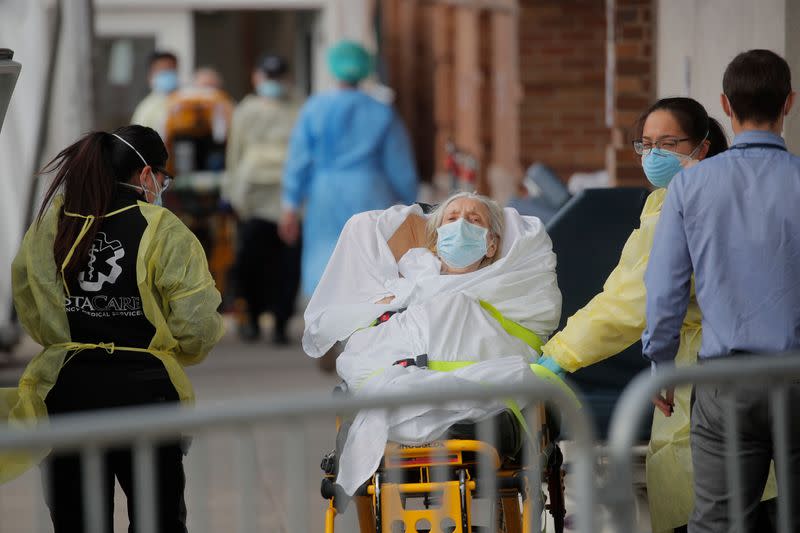 Paramedics take a patient into emergency center at Maimonides Medical Center during outbreak of coronavirus disease (COVID-19) in Brooklyn New York