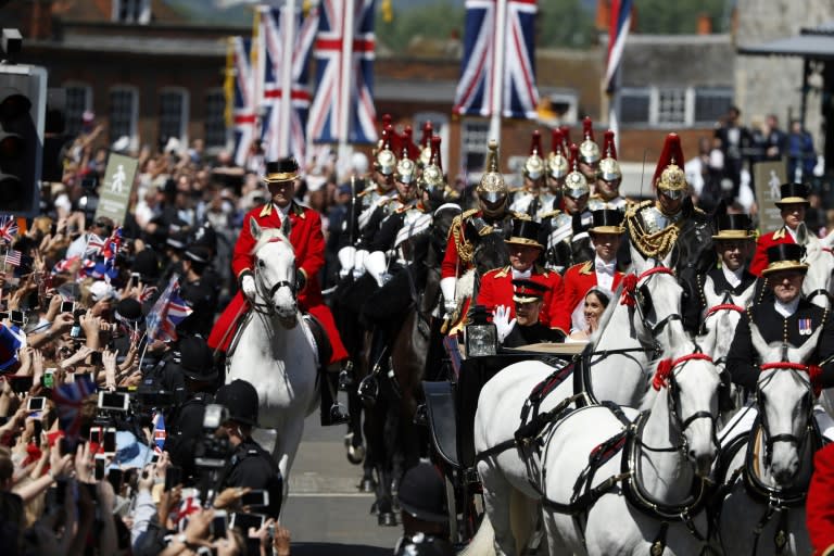 Crowds lined the streets of Windsor to cheer the royal couple as they parade in a horse-drawn carriage after the wedding