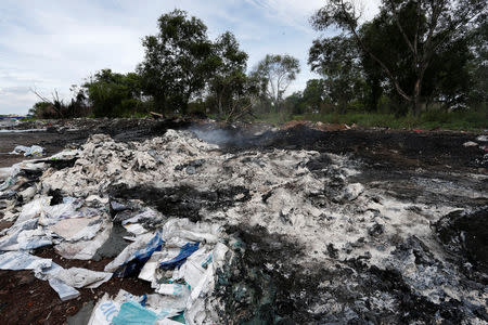 Burnt plastic waste from open burning is pictured on the roadside in Pulau Indah, Malaysia October 14, 2018. Picture taken October 14, 2018. REUTERS/Lai Seng Sin