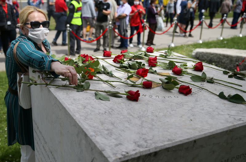 A protester places a rose at the World War Two monument during a protest against a mass for the Nazi collaborators, in Sarajevo