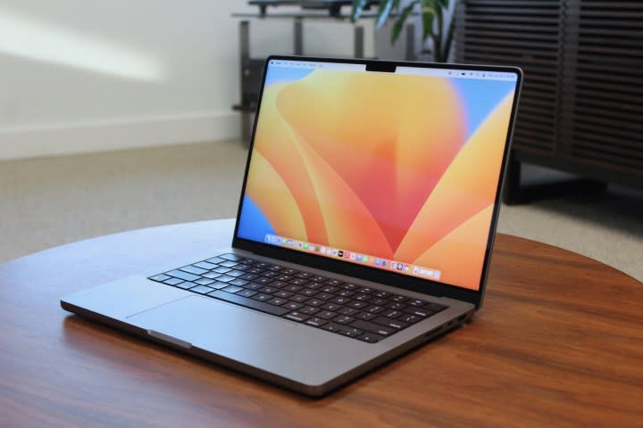 The MacBook Pro open on a wooden table.