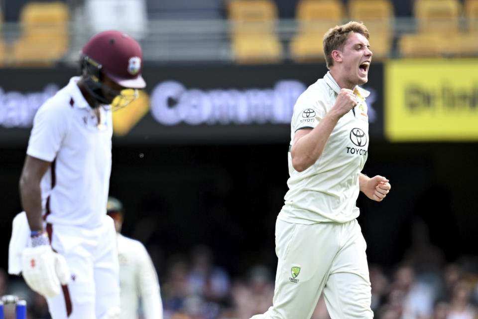 Australia's Cameron Green, right, celebrates taking the wicket ofWest Indies' Kraigg Brathwaite, left, on the third day of their cricket test match in Brisbane, Saturday, Jan. 27, 2024. (Darren England/AAP Image via AP)