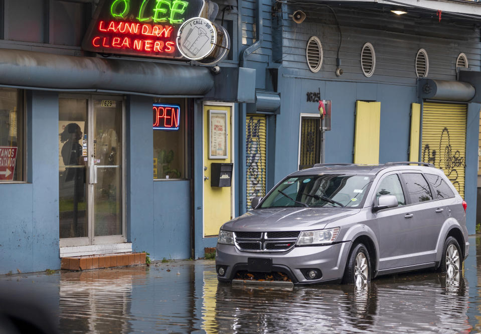 A customer waits inside a Treme neighborhood dry cleaner as the street floods from rain in New Orleans on Wednesday, April 10, 2024. Severe thunderstorms were expected across parts of the Louisiana, Mississippi, Alabama and the Florida panhandle and there was the potential for tornadoes, a few of which may be strong, and damaging winds, which may exceed 75 mph (120 kph), the National Weather Service warned.(Chris Granger /The Times-Picayune/The New Orleans Advocate via AP)