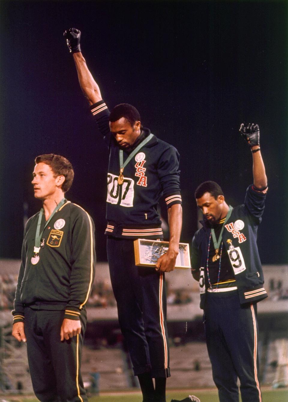 1968 Olympic Games, Mexico City, Mexico, Men's 200 Metres Final, USA gold medalist Tommie Smith (C) and bronze medalist John Carlos give the black power salute as an anti-racial protest as they stand on the podium with Australian silver medallist Peter Norman