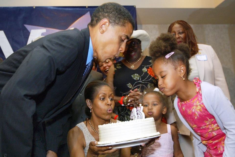 <p>Life as a politician's daughter includes celebrating your dad's birthday on the campaign trail! In 2004, Michelle, Sasha and Malia helped dear old dad blow out the candles on his birthday cake. </p>