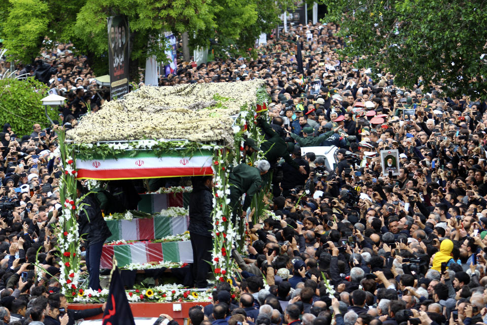 In this photo provided by Fars News Agency, mourners gather around a truck carrying coffins of Iranian President Ebrahim Raisi and his companions who were killed in their helicopter crash on Sunday in mountainous region of the country's northwest, during a funeral ceremony at the city of Tabriz, Iran, Tuesday, May 21, 2024. Mourners in black began gathering Tuesday for days of funerals and processions for Iran's late president, foreign minister and others killed in a helicopter crash, a government-led series of ceremonies aimed at both honoring the dead and projecting strength in an unsettled Middle East. (Ata Dadashi, Fars News Agency via AP)